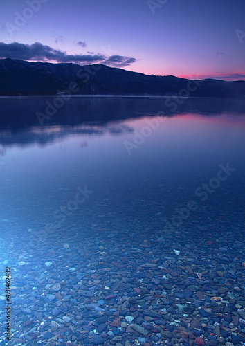 鮮やかな紫色のグラデーションの空のクリアな湖の夜明け。北海道の屈斜路湖。