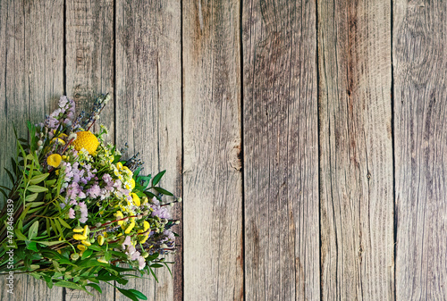 flowers bouquet in yellow-violets colors on old rustic wooden background. Beautiful floral image. spring summer seasonal flowers. top view. copy space