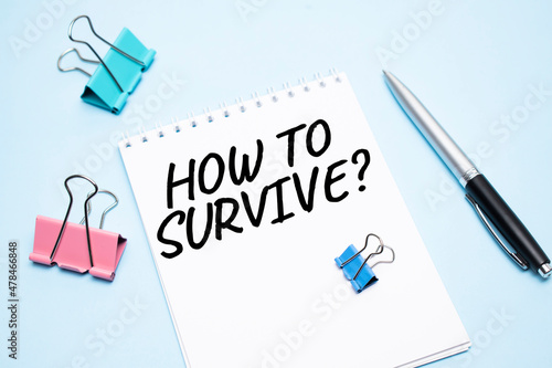 White notepad with text How to survive and office tools on the blue backgroundd