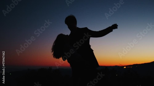 Silhouette di una coppia al tramonto che balla per san Valentino photo