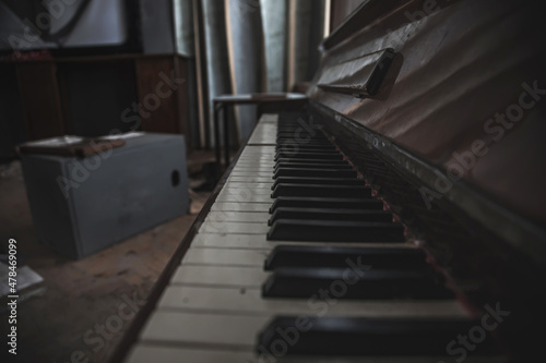 A beautiful perspective of the keys of an old abandoned piano. An ancient musical instrument. Black and white keys. Old abandoned interior.