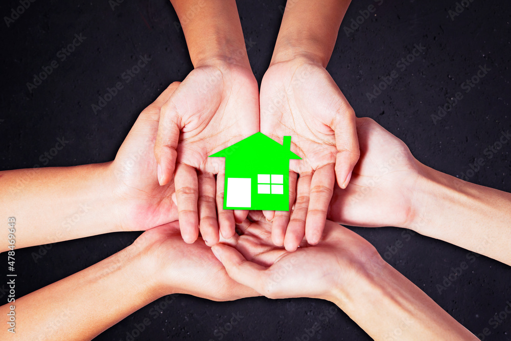 Close up of happy family hands hold house symbol Close up of happy family hands hold house symbol