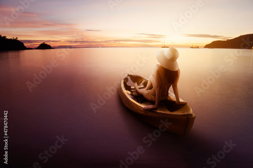 Canvas-taulu Young woman sitting on the canoe boat at sunset