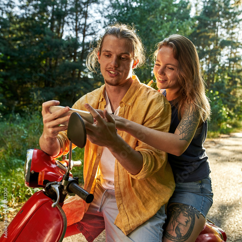 Smiling young caucasian couple looking into smartphone