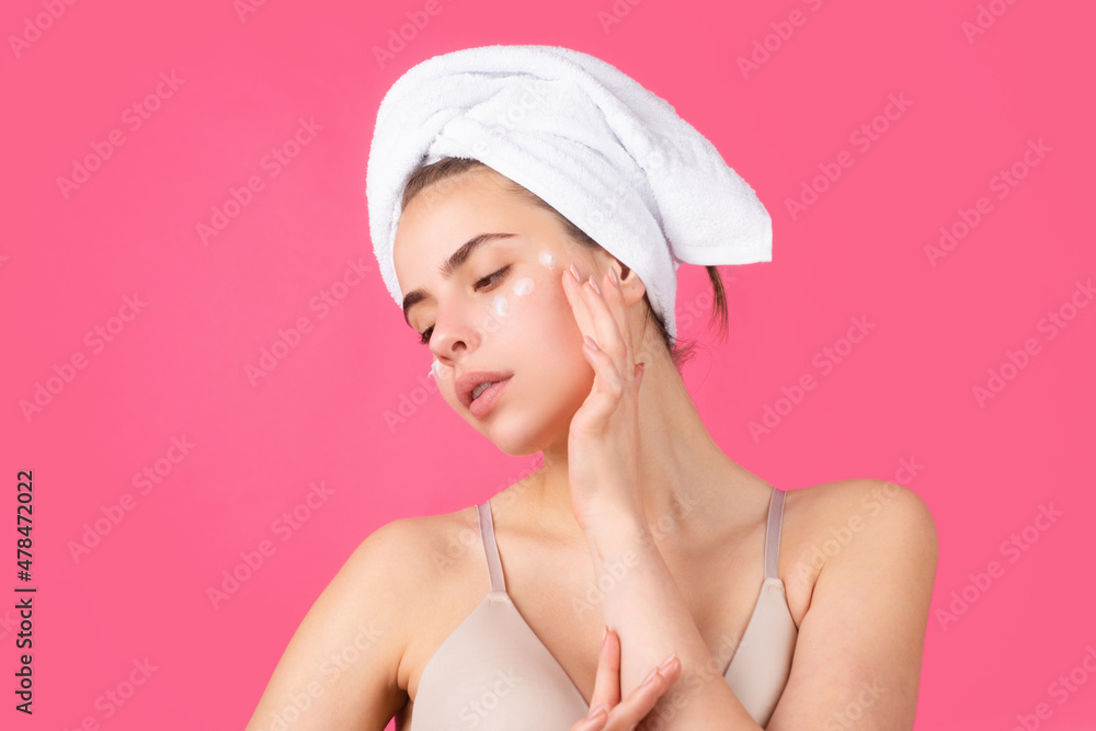 Cosmetic cream on woman face with clean soft skin. Woman with towel applying cream on skin. Body care and spa salon concept. Spa sensual girl. Beautiful young woman with perfect skin. Cosmetic cream on woman face with clean soft skin. Woman with towel applying cream on skin. Body care and spa salon concept. Spa sensual girl. Beautiful young woman with perfect skin.