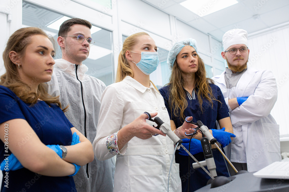 Obraz premium Medical students practice laparoscopy surgery with a teacher on a modern simulator. Training of surgeons.