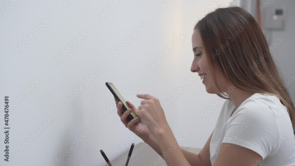 Gorgeous Young Woman Smiling While Chatting On Smartphone. medium shot, side view Gorgeous Young Woman Smiling While Chatting On Smartphone. medium shot, side view