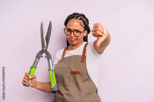 black afro woman feeling cross,showing thumbs down. gardenner or farmer concept photo