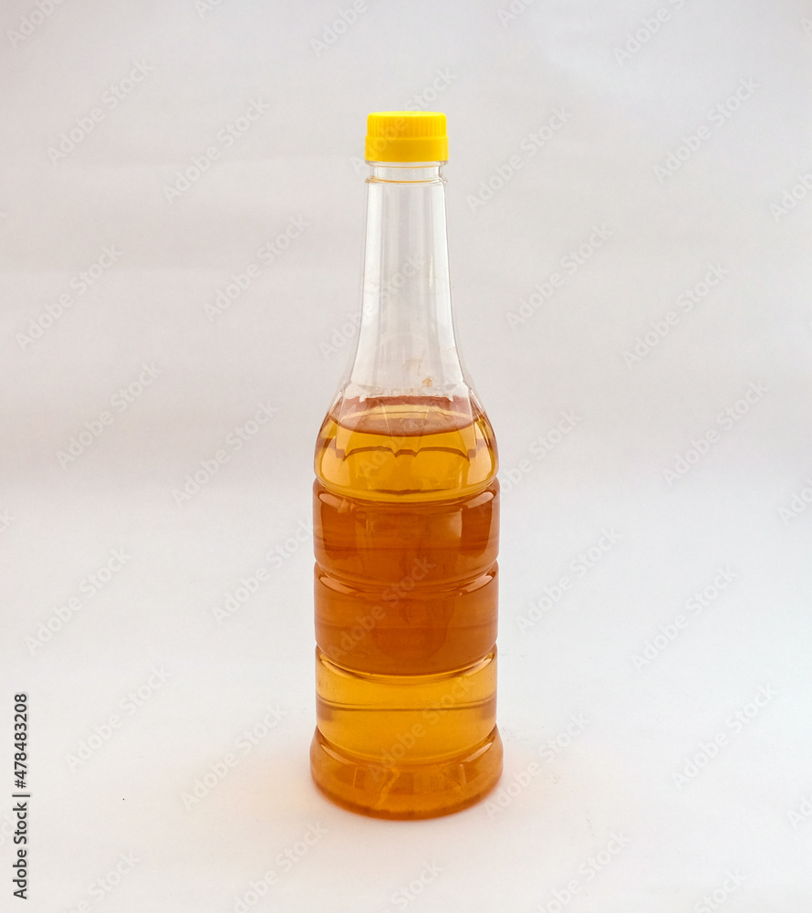 Little apple cider vinegar in a transparent bottle stands in the background. Selective focus. Space for text. Little apple cider vinegar in a transparent bottle stands in the background. Selective focus. Space for text.