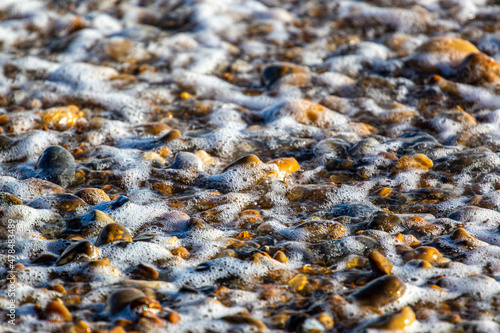 Pebbles on a beach as waves break photo