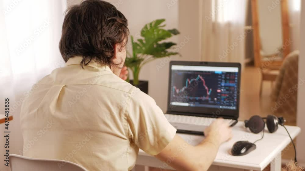 cryptocurrency market, chart on laptop screen, man working at home. Lost all money, price fell down, shocked, sad, banging his head on table, suffering, ruined. cryptocurrency market, chart on laptop screen, man working at home. Lost all money, price fell down, shocked, sad, banging his head on table, suffering, ruined.