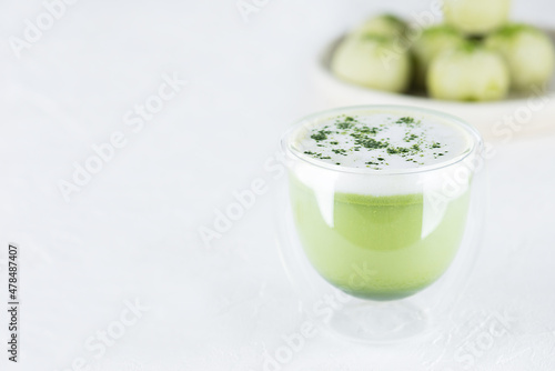 Matcha latte tea with sweet truffles on the table. Sugar, gluten and lactose free and vegan. Horizontal orientation, copy space.