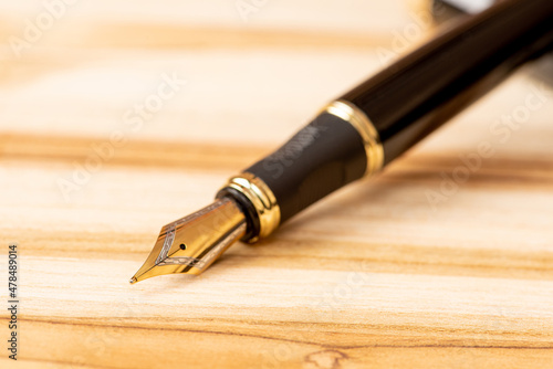 Fountain pen, beautiful fountain pen positioned on a rustic wooden surface, selective focus.