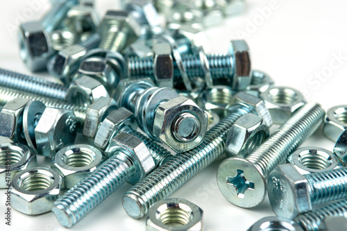 A large group of silver fasteners for fastening structures. Bolts and nuts with washers close-up on a white background. photo