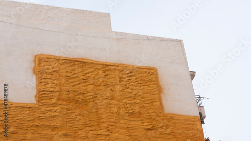 Rastro de edificio cubierto de espuma aislante dorada en pared medianera photo