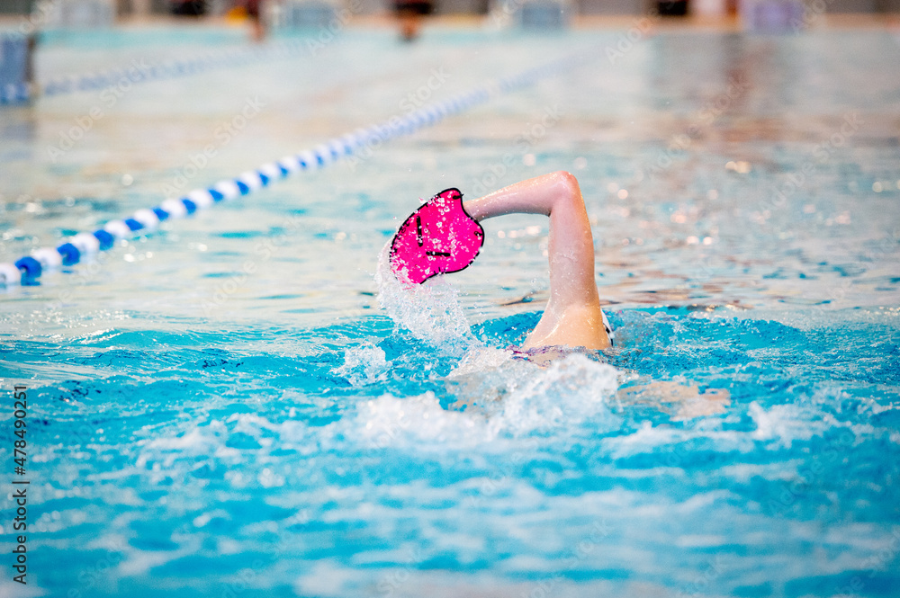 Swimmer trains in swimming pool using swimming equipment Stock Photo