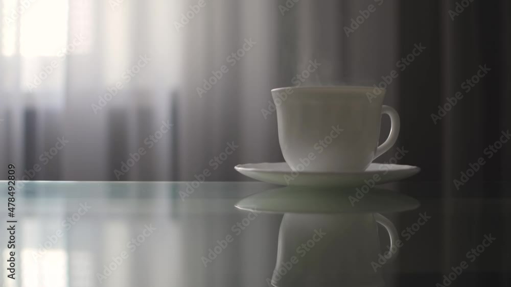 a cup of coffee is on the table, steam is coming out of the cup a cup of coffee is on the table, steam is coming out of the cup