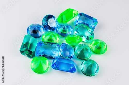 Handful of blue and green gems on white background