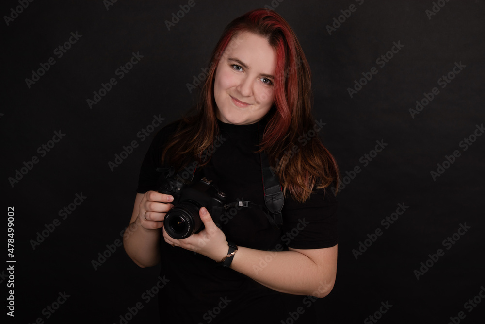 redhead girl with a professional camera posing on black background. woman female photographer redhead girl with a professional camera posing on black background. woman female photographer
