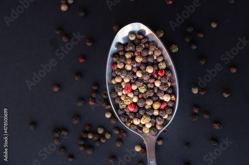 Various colored pepercorns on a dark background photo