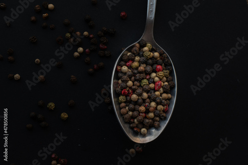 Various colored pepercorns on a dark background photo