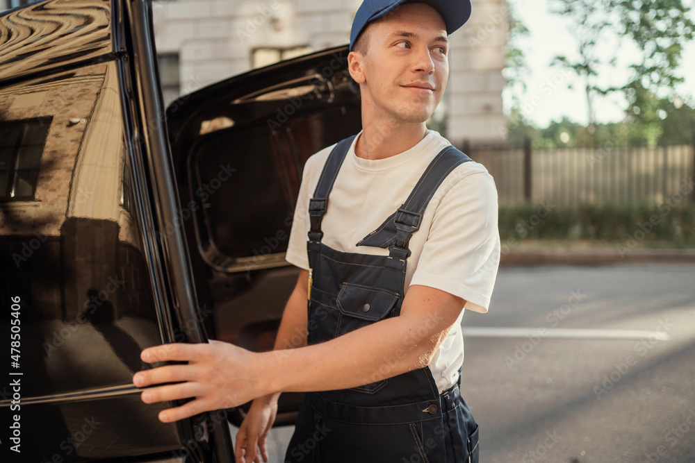 The driver of the courier service. Delivery of a box of products and goods to your home. Employee in uniform logistics company. Fast delivery of the goods. The driver of the courier service. Delivery of a box of products and goods to your home. Employee in uniform logistics company. Fast delivery of the goods.