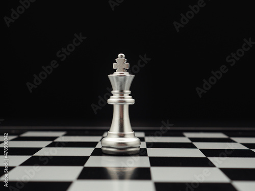 Chess piece on board game planning and competition on black background