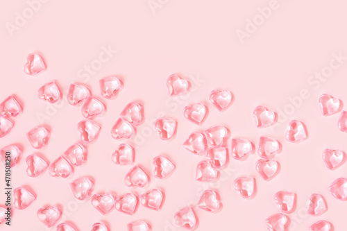 St Valentines day pink background border. Many glass hearts flat lay. Love or wedding concept