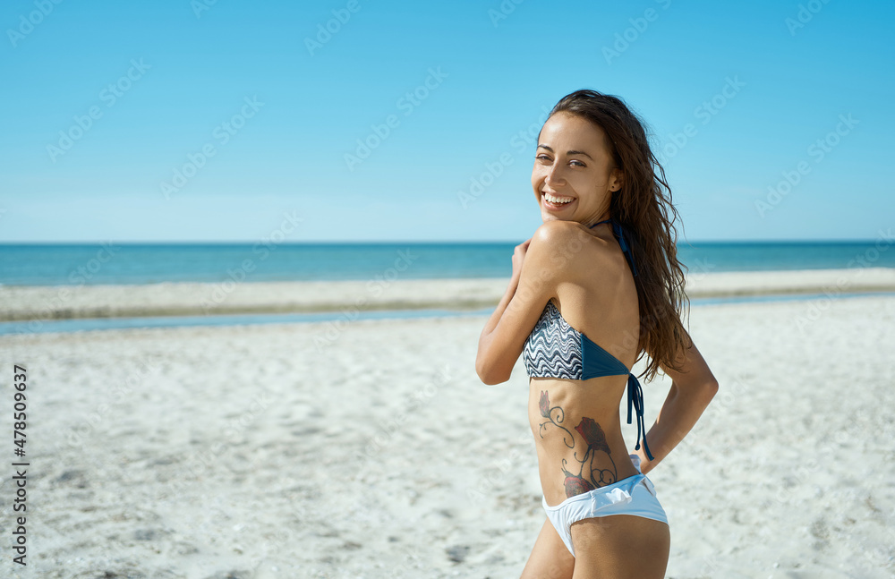 Cheerful bikini woman running on tropical paradise beach. Portrait of happy playful girl having fun during vacation Cheerful bikini woman running on tropical paradise beach. Portrait of happy playful girl having fun during vacation