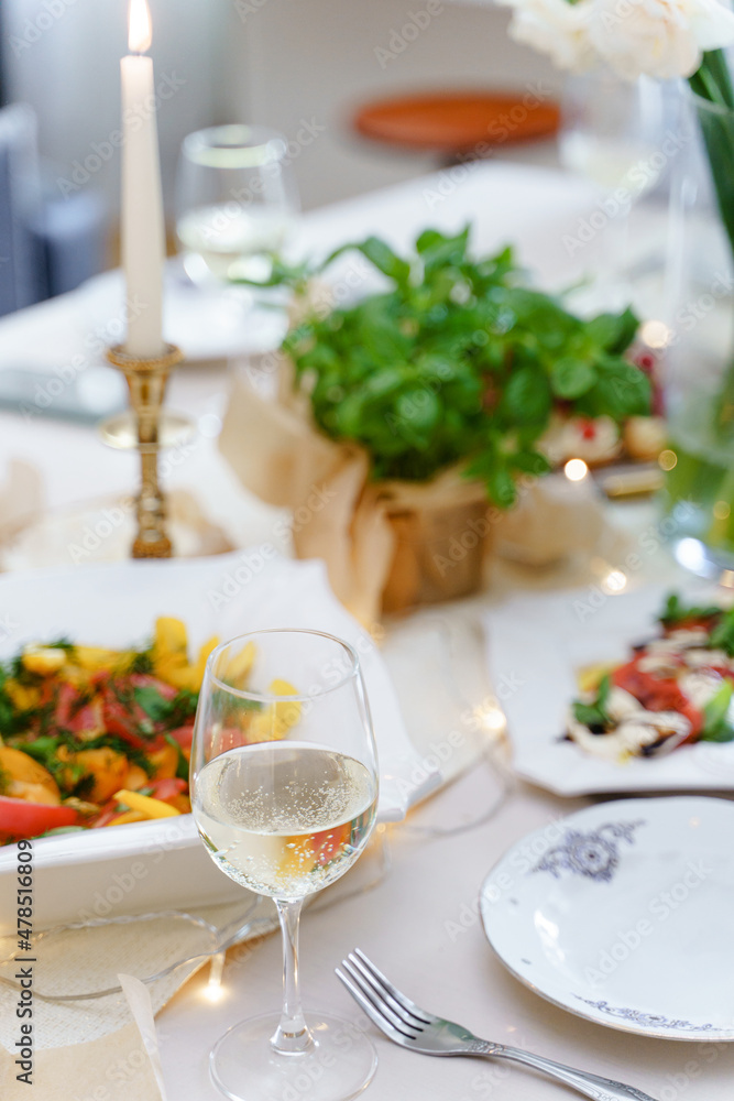 Festive table with food, wine, flowers and candles.