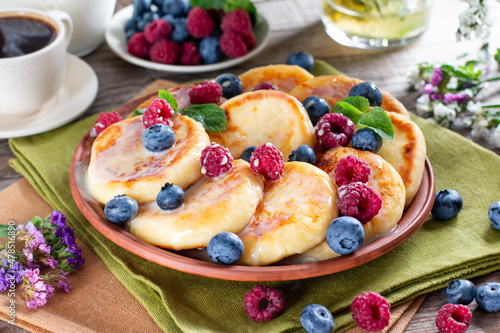 Breakfast with cheesecake, fresh berries . Cottage cheese pancakes or curd fritters. Russian syrniki or sirniki with condensed milk