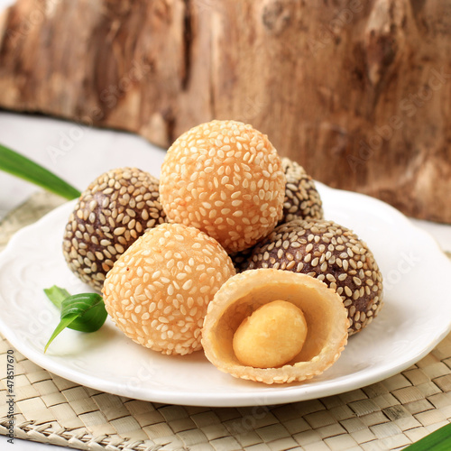 Onde-Onde is traditional food from Indonesia made from glutinous rice flour with beans pasta, wrapped in sesame seeds. Popular Indonesian  with Chinese influence. Served in white plate, close up. photo