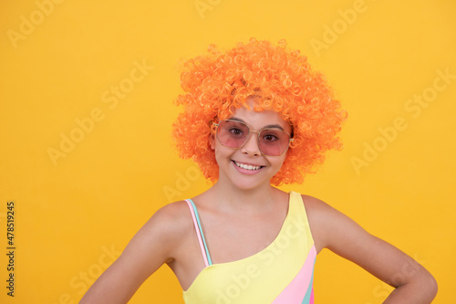 lets have fun. birthday party. funny kid in curly clown wig. having fun.