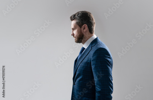 Canvas Print Serious business professional man stand sideway in suit grey background copy spa