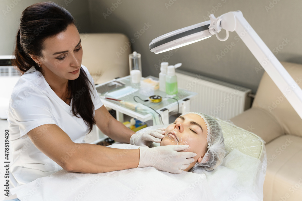 Professional permanent makeup artist applying anesthetic cream Professional permanent makeup artist applying anesthetic cream