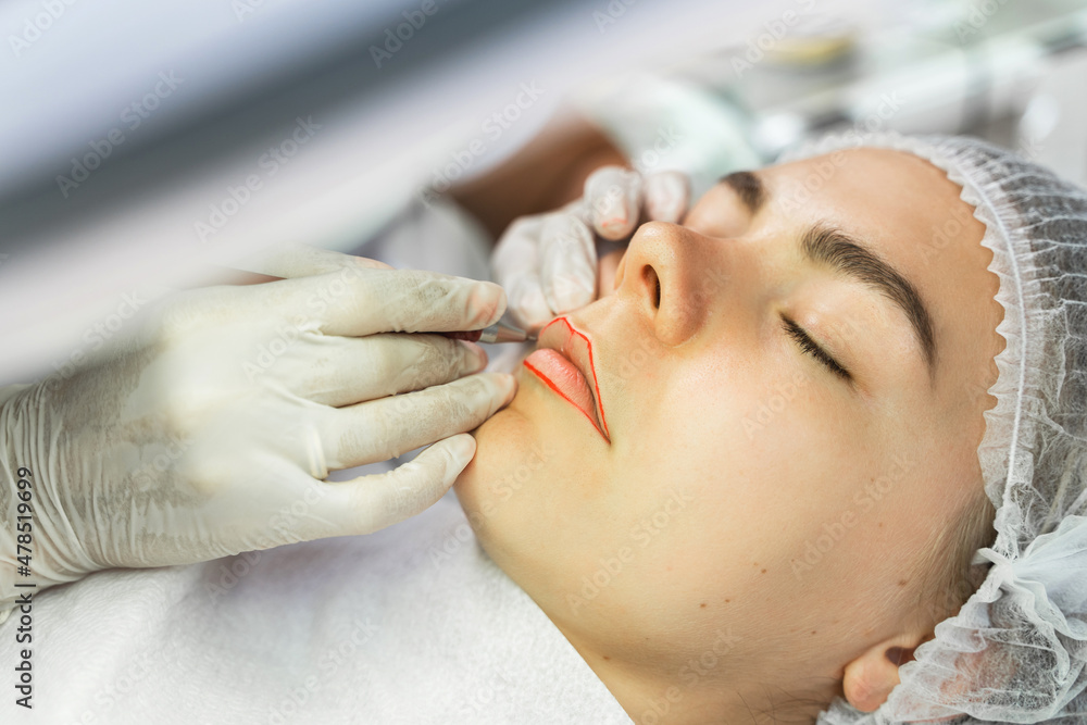 Permanent makeup artist and her client during lip blushing procedure Permanent makeup artist and her client during lip blushing procedure
