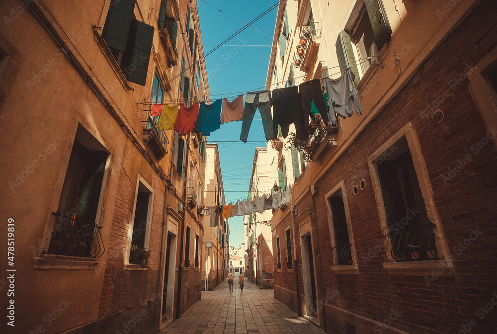 Narrow streets with washed laundry drying over historical city Venice