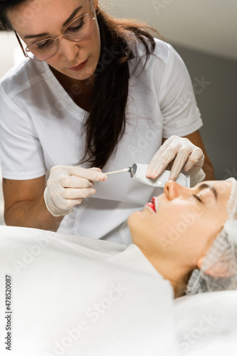 Professional permanent makeup artist applying anesthetic cream