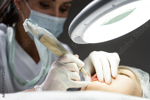 Принти на полотні Permanent makeup artist and her client during lip blushing procedure