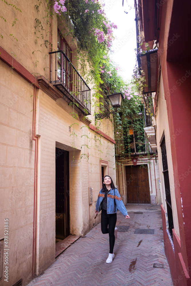 young attractive Asian woman walking in a traditional street in Seville