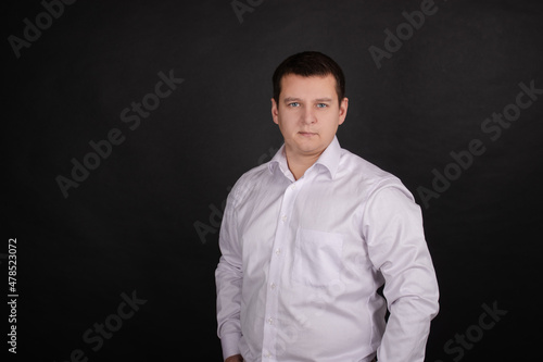 portrait of a handsome man in a white shirt on a black background. business style, office wear. businessman.
