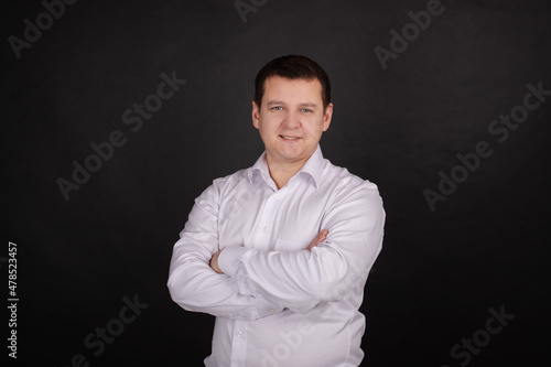 portrait of a handsome man in a white shirt on a black background. business style, office wear. businessman.