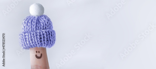 Fingers in knitted warm small hats, winter season concept