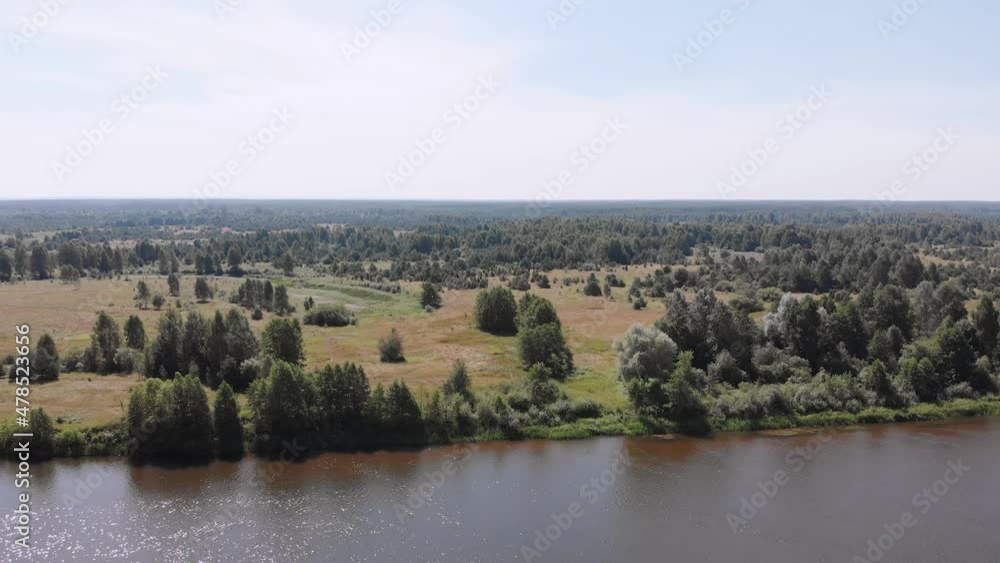 Aerial views of sparkling river, shore with grass, trees and shrubs. Endless space, view of perfect plain with forest. Summer scenic landscape on sunny day. Movement of camera is parallel to coast. Aerial views of sparkling river, shore with grass, trees and shrubs. Endless space, view of perfect plain with forest. Summer scenic landscape on sunny day. Movement of camera is parallel to coast.