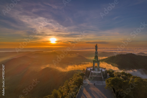 foto con dron de un amanecer con la estatua de san salvador en la isla de majorca con la niebla en las montañas de fondo photo