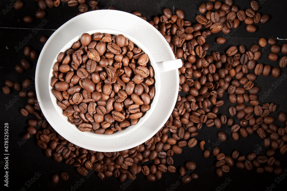 Fototapeta premium Cup of aromatic coffee with coffee beans on a dark background