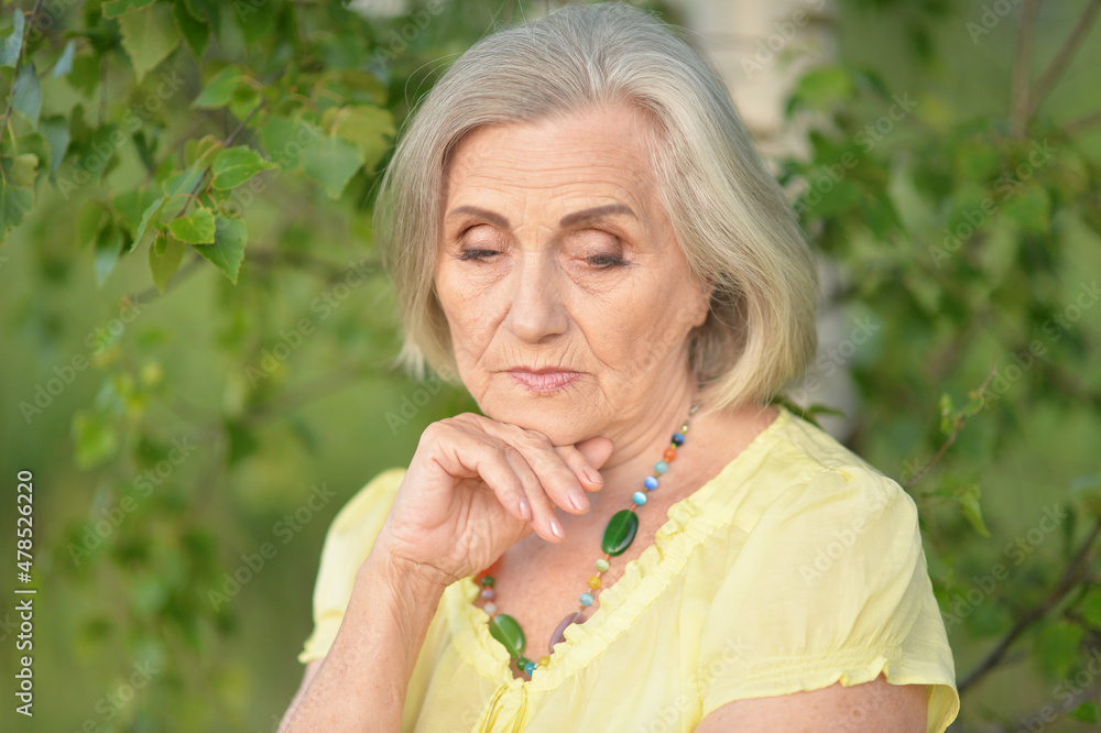 Portrait of sad senior beautiful woman in spring park Portrait of sad senior beautiful woman in spring park
