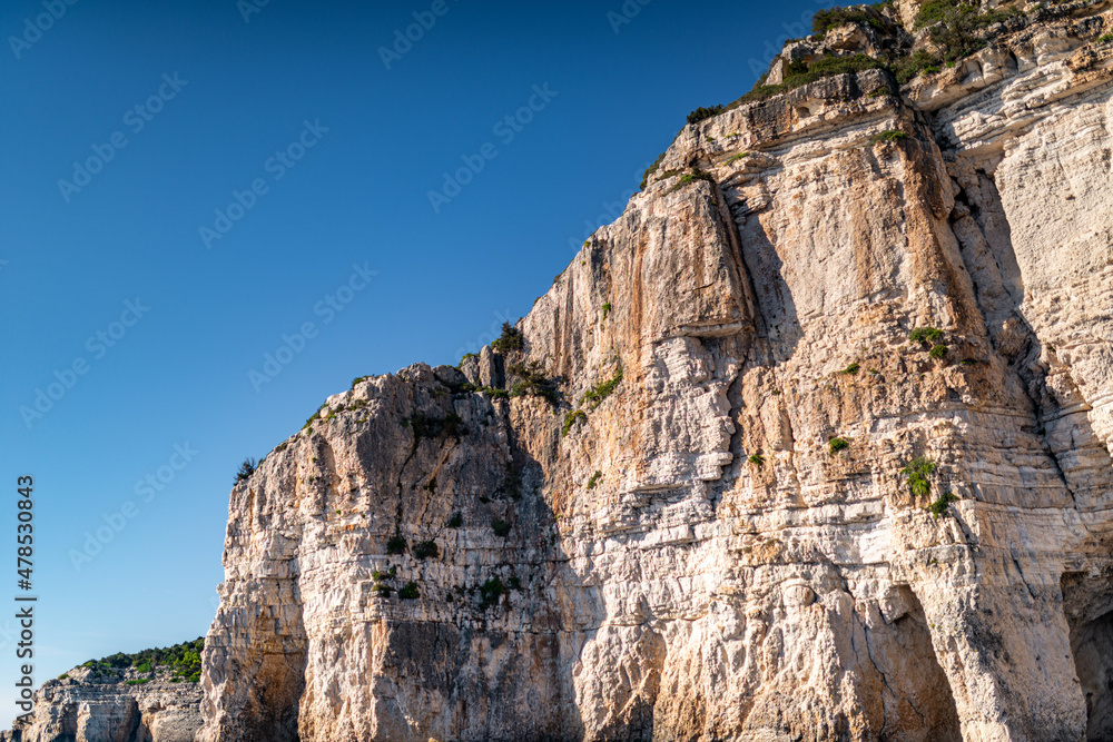 High cliffs with forest and rocks on shore of Corfu island