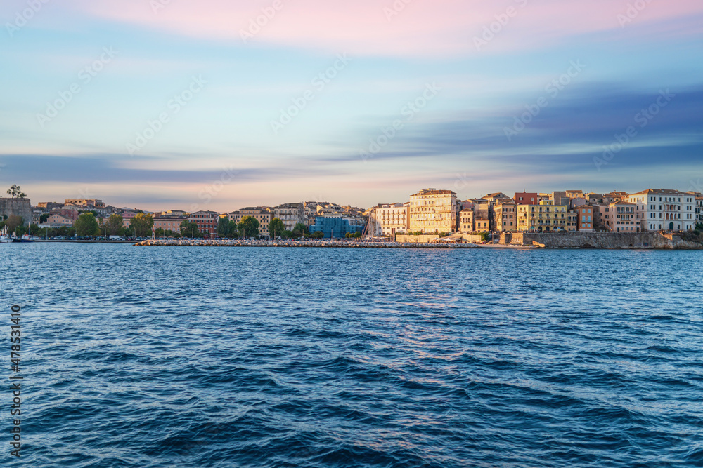 Fototapeta premium Buildings of Corfu island on shore and sea water at sunset