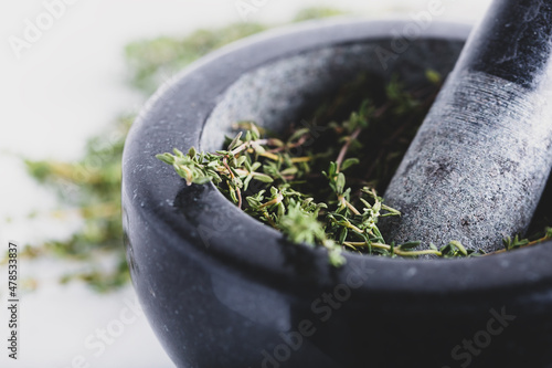 Bunch of fresh herbs in gray stone mortar with pestle photo